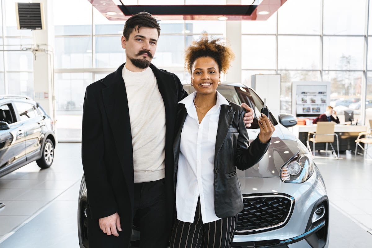 Couple collecting their new car subscription from a dealership
