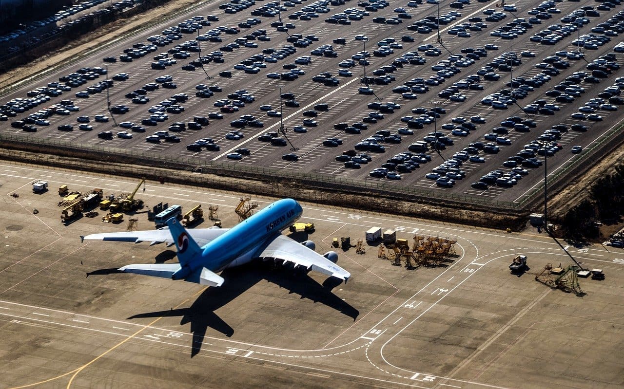 Airplane next to large car park