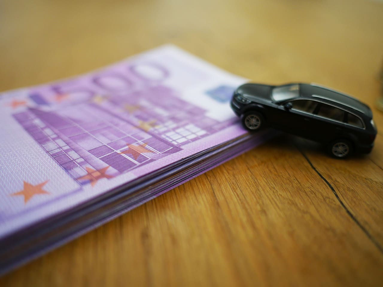 Model car parked on top of a pile of Euro Notes
