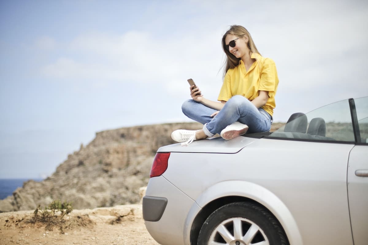 GIrl sat on the back of a silver Renault Megane Coupe-Cabriolet
