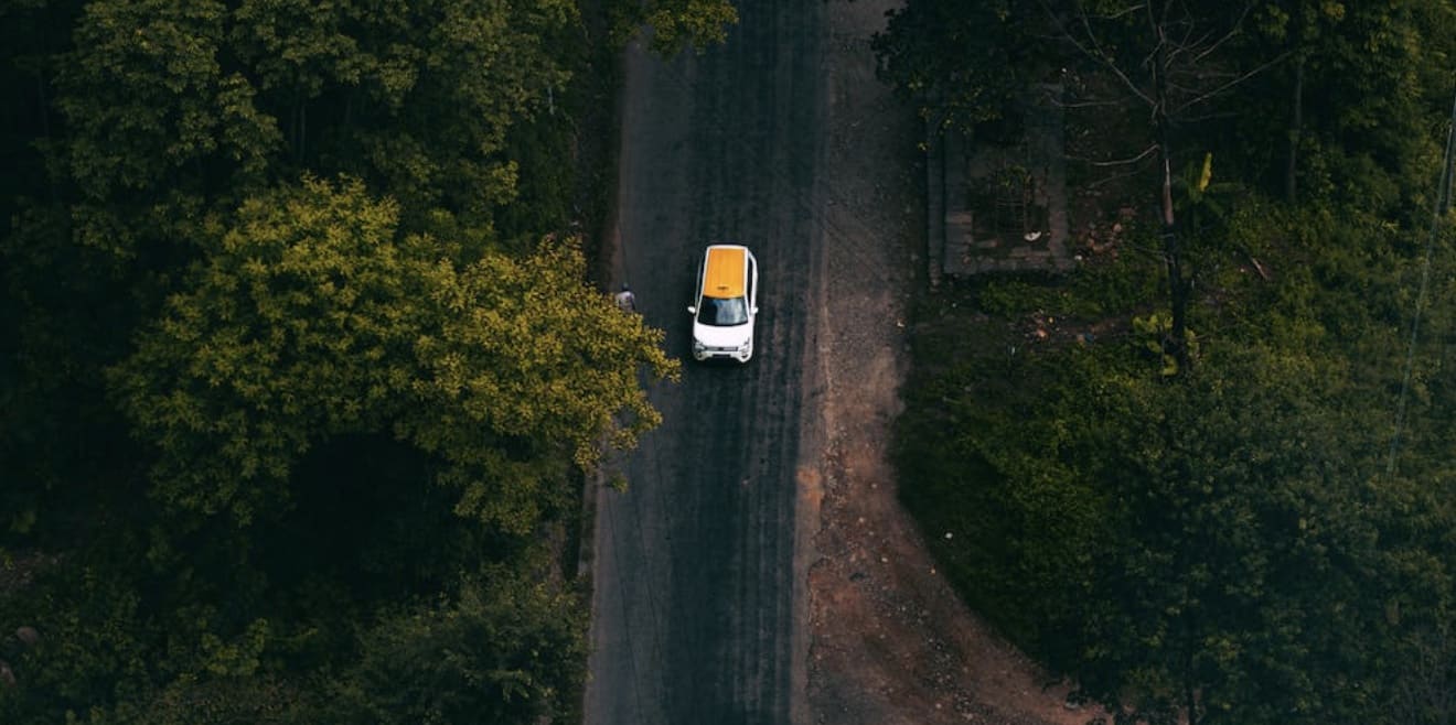 Car from overhead, driving through woodland