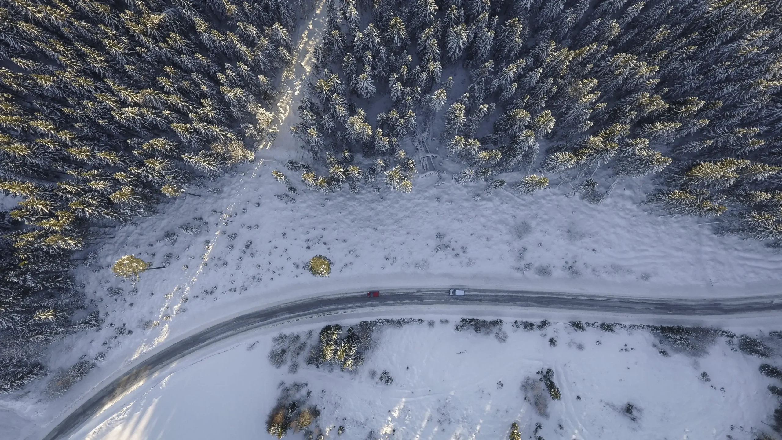 Drone shot of a very snowy road in the forest